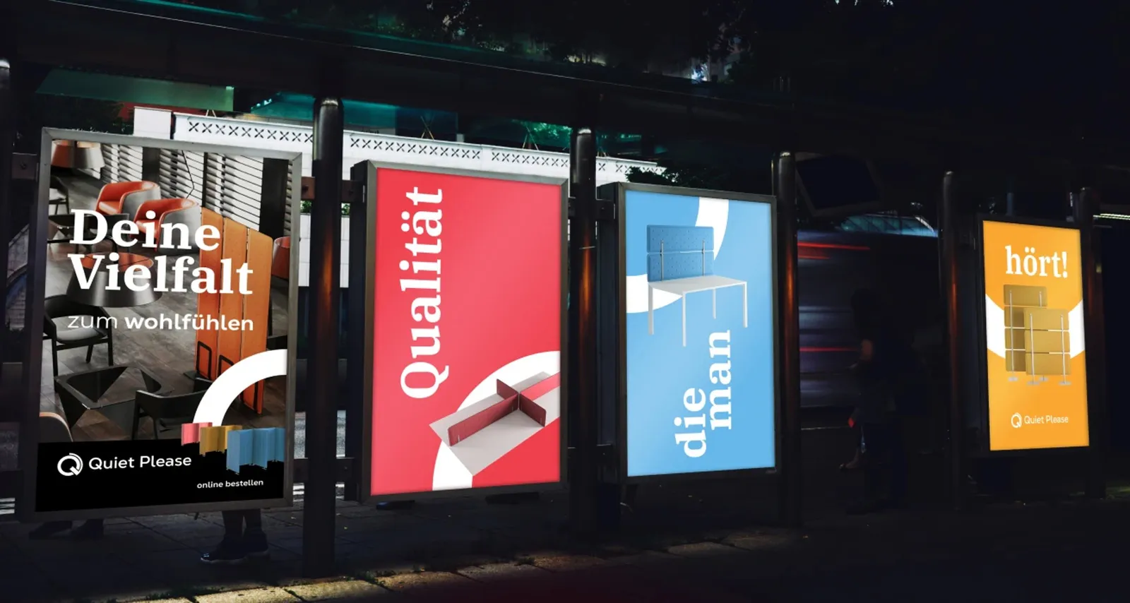 Four illuminated poster cases at night, each in a different accent color