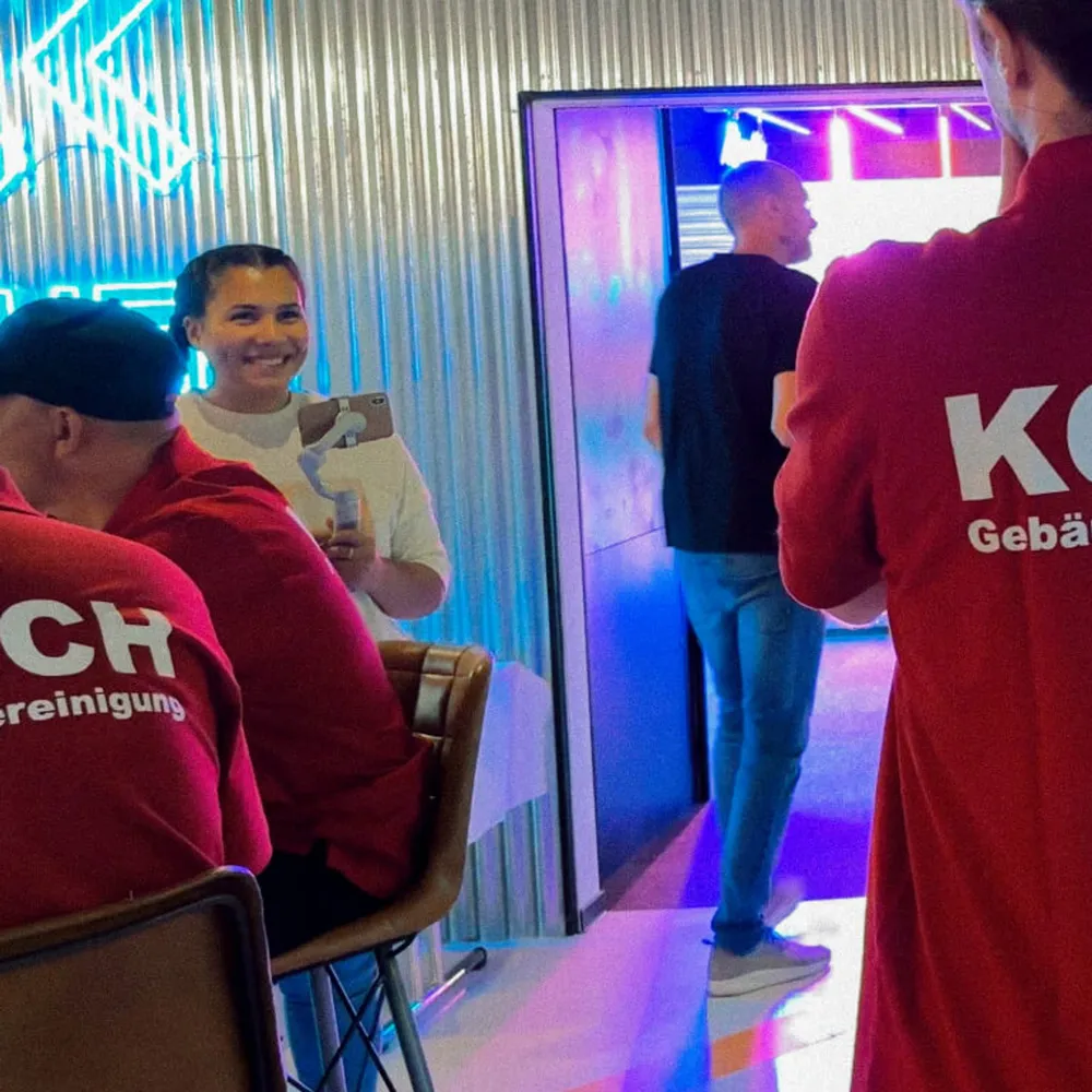 The team in red Koch shirts in the neon light of the kart track