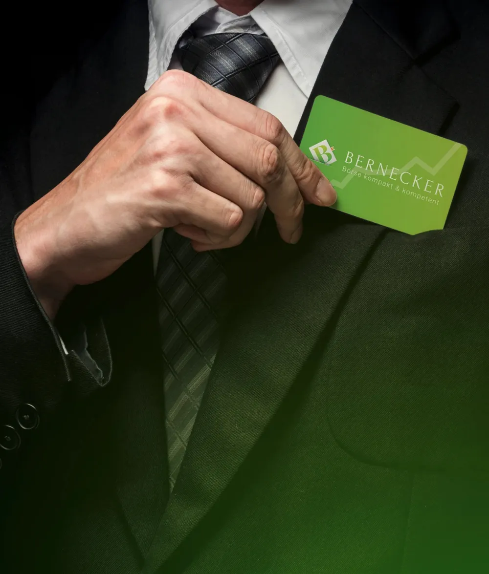 A hand slipping the green Bernecker card into the breast pocket of a suit