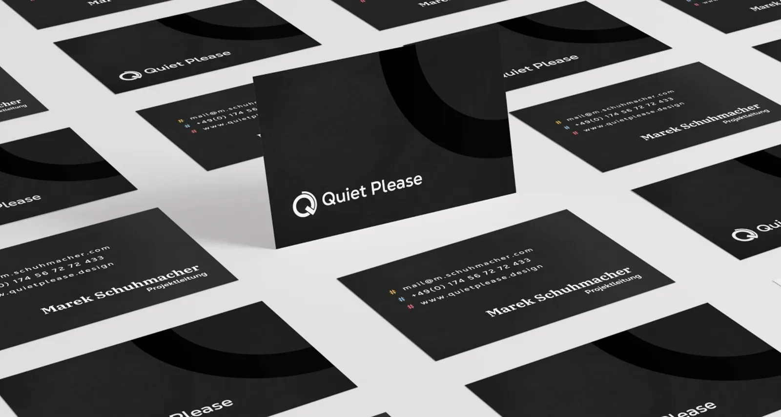 Fanned-out business cards in black and white with logo and contact details
