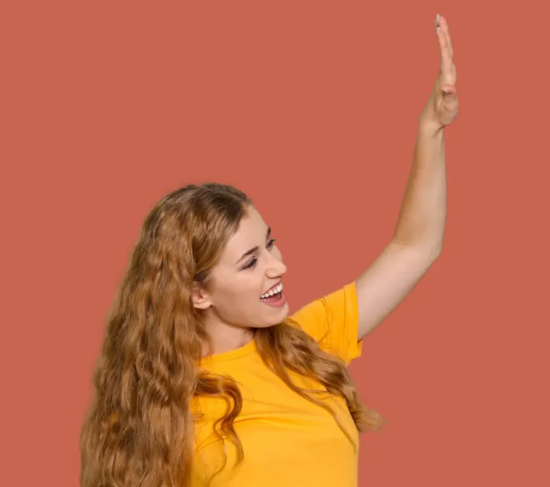 A laughing woman in a yellow shirt high-fives, cut out on rust red