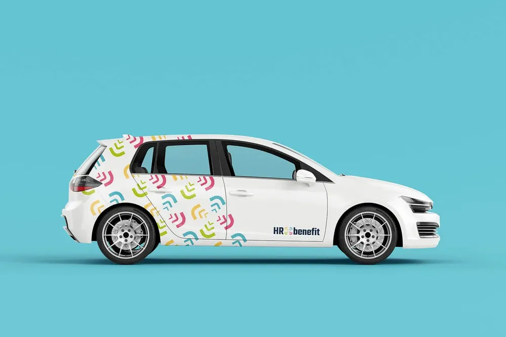 White compact car with a pattern wrap made from the brackets of the symbol and the logo on the door