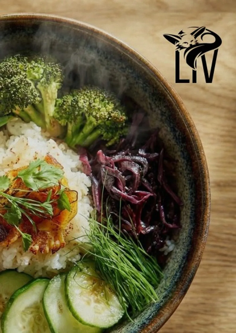 Bowl of rice, broccoli and vegetables from above, with the Liv logo on the bowl beside it