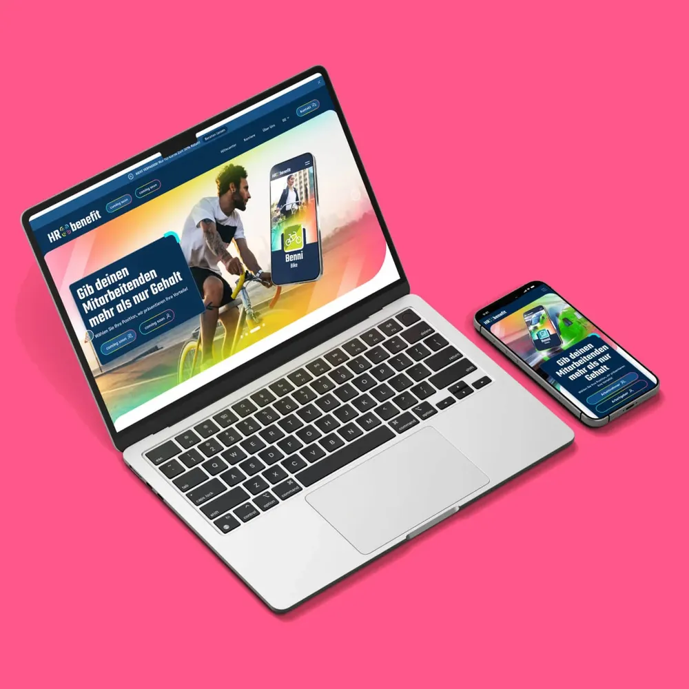 Laptop and smartphone on a pink background, both showing the home page “Give your employees more than just a salary”