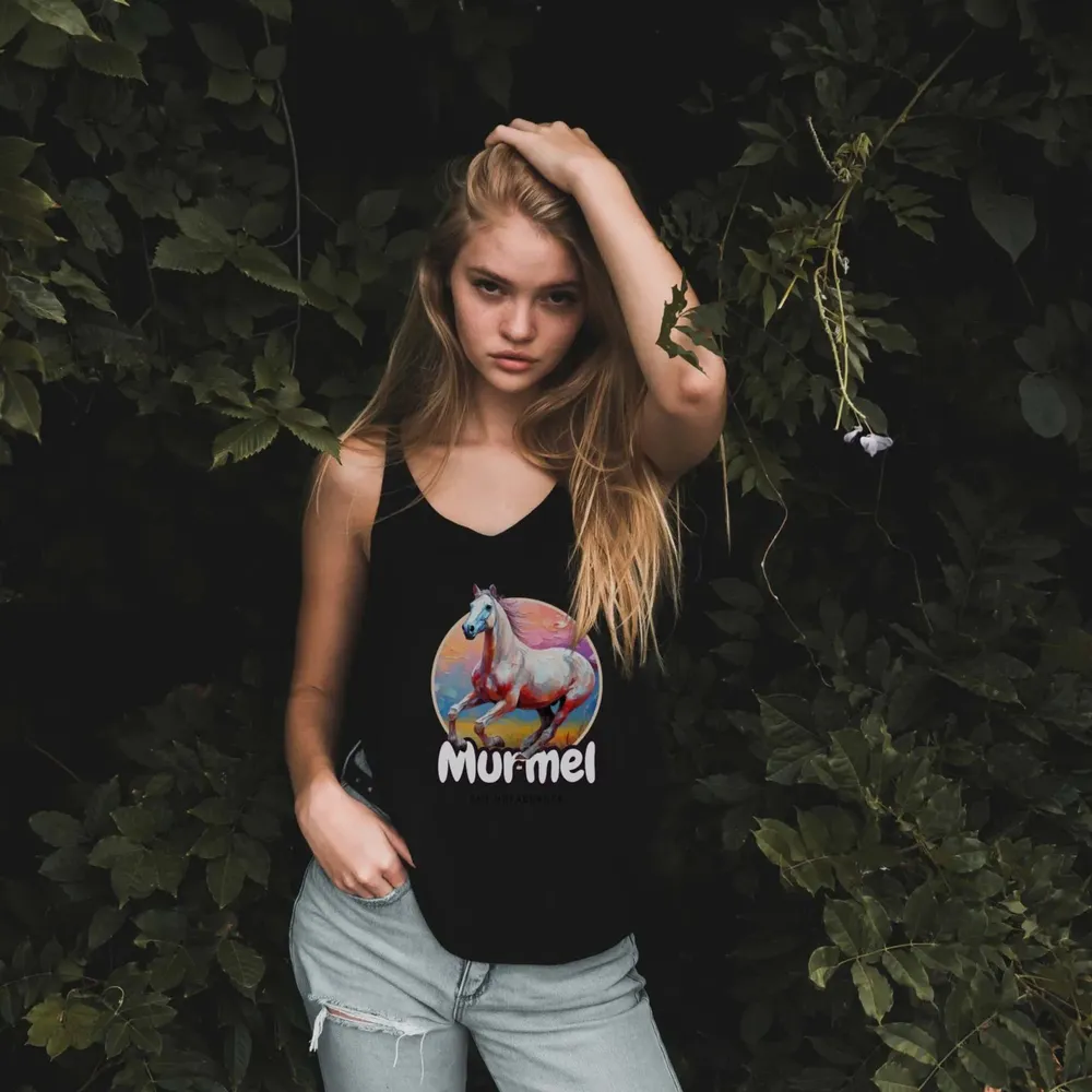 Young woman in a black top with the “Murmel” design in front of dark foliage