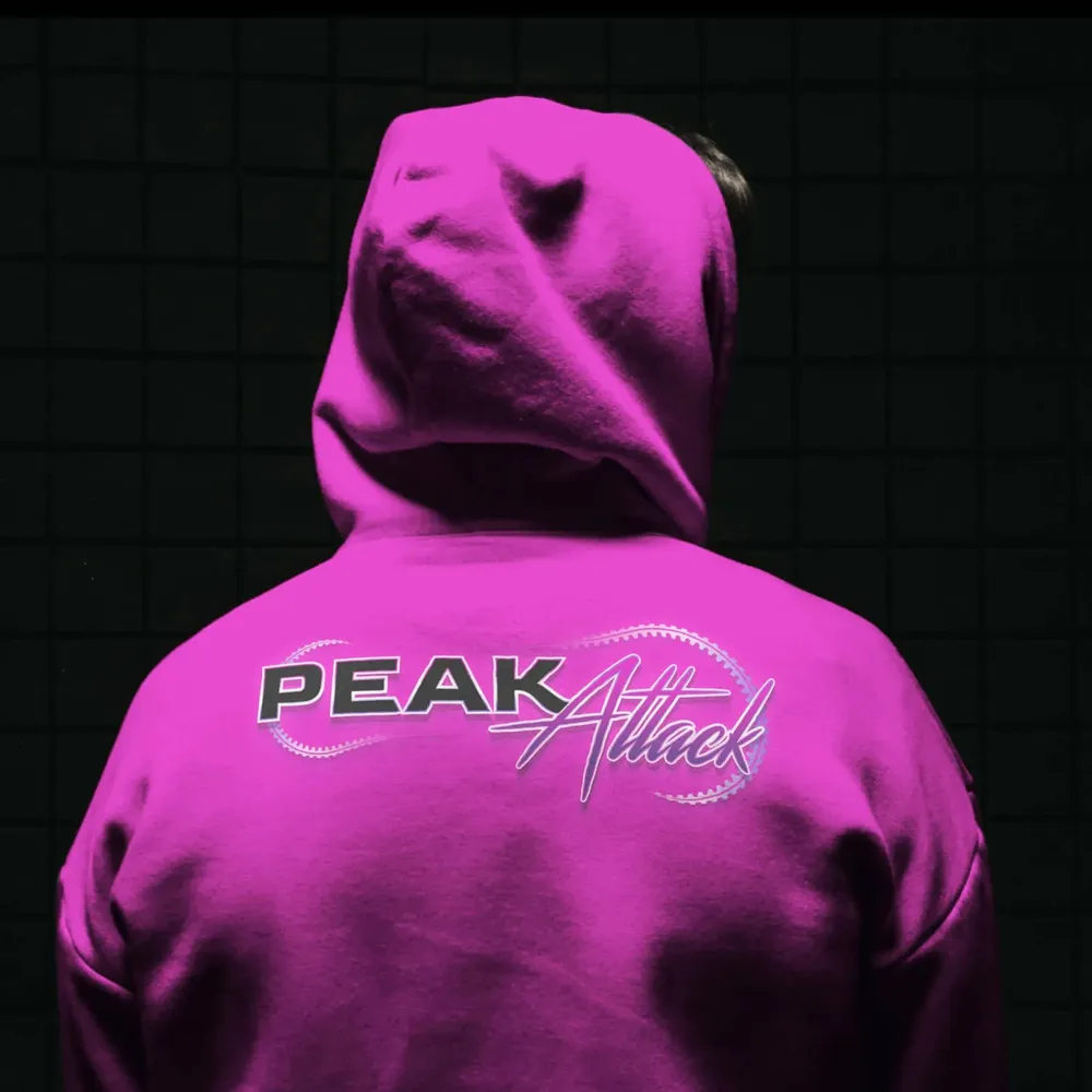 Magenta hoodie seen from behind with the Peak Attack wordmark