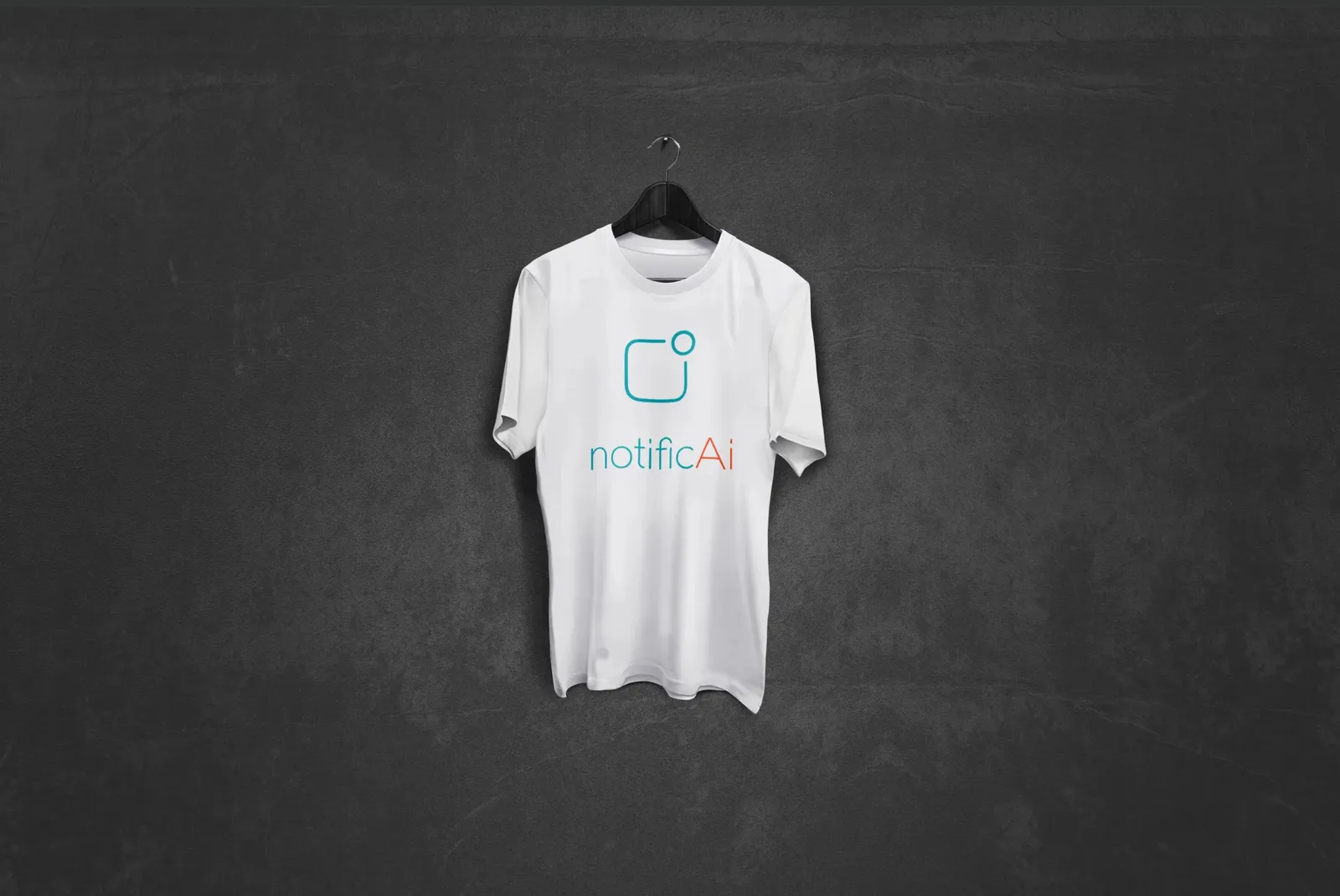 A white T-shirt with the notificAi logo on a hanger in front of a dark wall