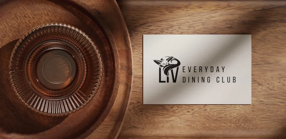 Business card with the Liv logo on a turned wooden bowl