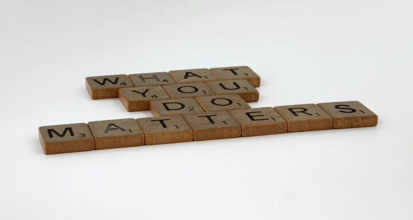 Holzbuchstaben auf weißem Grund bilden den Satz „What you do matters“