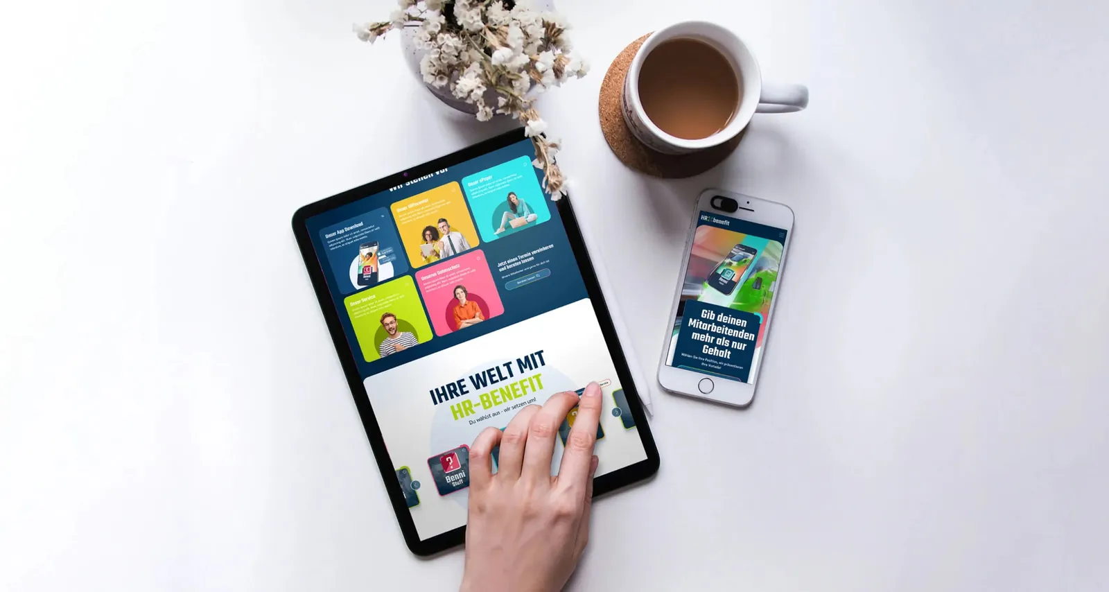 Tablet and smartphone on a light table, both showing the new HR Benefit website